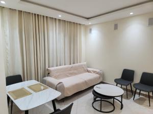 杜阿拉ET1G Maguia Home - City Suite Veranda的一间有床、桌子和椅子的房间