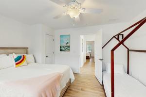a white bedroom with two beds and a ceiling fan at Bowen Village 6110 in Charleston +52 photos