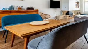 a living room with a wooden table and blue chairs at Alpine Reither Retreat Kitzbuhel in Kitzbühel +3 photos