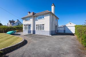 a large white house with a driveway at Dolwar in Abersoch