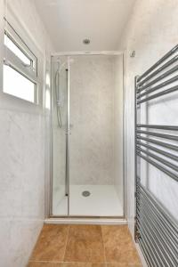 a shower with a glass door in a bathroom at Dolwar in Abersoch