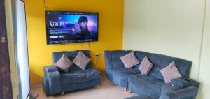 a living room with two couches and a flat screen tv at CASA EN EL BARRIO CÁNDIDO CERCA AL CC ÚNICO y AL AEROPUERTO in Neiva