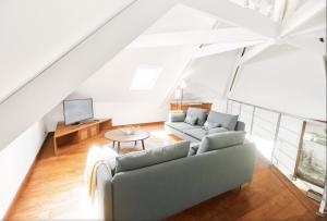 a living room with a couch and a tv at Villa Jasmin & Bungalow Pool House 4 étoiles - 18 voyageurs in Le Tampon