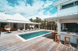 a deck with a swimming pool and a house at Villa Jasmin & Bungalow Pool House 4 étoiles - 18 voyageurs in Le Tampon
