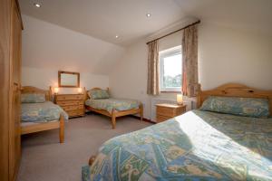 a bedroom with two beds and a window at Bragdy Wern in Llanbedrog