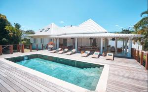 a house with a swimming pool on a wooden deck at Villa Jasmin & Bungalow Pool House 4 étoiles - 18 voyageurs in Le Tampon