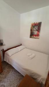 a bedroom with a bed with two white towels on it at Comfort and unparalleled view in Kóronos
