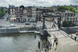 a city with a bridge over a river with buildings at Canal House Inn in Amsterdam