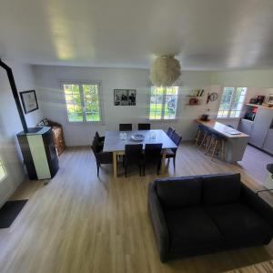 een woonkamer met een zwarte bank en een tafel bij Détente à la mer Blanche in Fouesnant