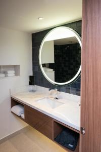 Courtyard by Marriott Puebla Las Animas في بوبلا: حمام مع حوض ومرآة