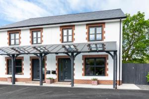 a detached house with a black and white facade at Tyisaf in Llanfynydd