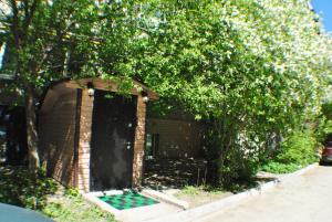 a brick building with a black door and trees at MiniHotel Vavilon in Yekaterinburg