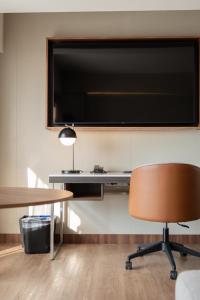 Courtyard by Marriott Puebla Las Animas في بوبلا: مكتب به تلفزيون كبير على الحائط