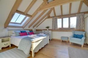 a bedroom with a bed and a chair in a attic at Churchlands Barn in Stone +51 photos