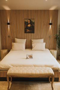 a bedroom with a large bed with a bench in it at Da Mona in Reims +1 photo