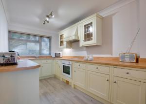 サンダースフットにある3 Strandways Courtの白いキャビネットとカウンタートップを備えたキッチン +10枚の写真