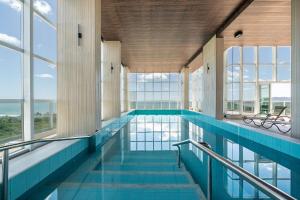 an indoor swimming pool with windows and a large swimming pool at Riviera Bela Vista 3 Suítes by Achei Camboriú in Itajaí