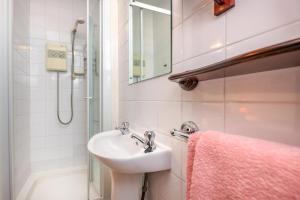 a bathroom with a sink and a shower at Rose Cottage in Llanbedrog +8 photos