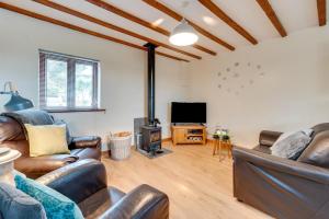a living room with leather furniture and a tv at Ysgubor in Y Felinheli