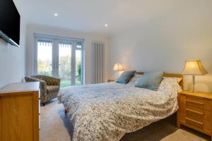 a bedroom with a bed and a chair and a television at Sandpipers in Rottingdean +8 photos