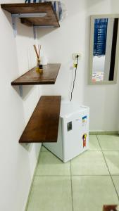 Un microondas junto a una pared con una mesa. en Pousada Mar e Sol, en Peruíbe