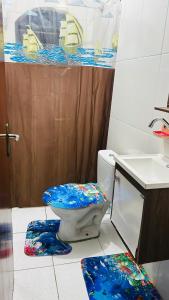 baño con aseo con tapa azul en Pousada Mar e Sol, en Peruíbe