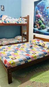 un letto con una trapunta in una stanza di Pousada Mar e Sol a Peruíbe