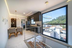 a kitchen and dining room with a large window at Condomínio Green Ville Residence | Bombinhas | SC in Canto Grande