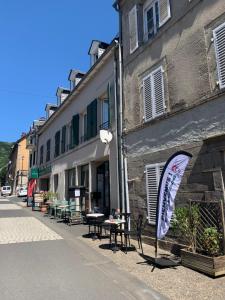 un edificio con un cartello sul lato di una strada di Chez Burons&Bouchons, Le Refuge Gourmand et Authentique a Condat