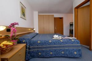 Habitación de hotel con cama y cesta de fruta en Albergo Antico, en Predazzo