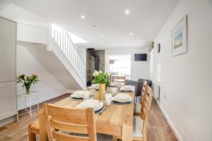 ein Esszimmer und eine Küche mit Tisch und Stühlen in der Unterkunft Yr Hen Barlwr in Llanddyfnan