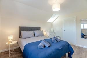 ein Schlafzimmer mit einem großen Bett mit blauer Bettwäsche in der Unterkunft Yr Hen Barlwr in Llanddyfnan