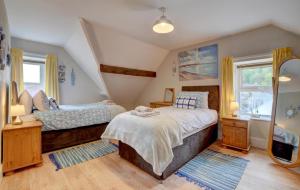 Un dormitorio con dos camas y un espejo. en Clifton House, en Lynmouth