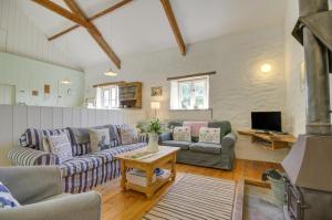 een woonkamer met twee banken en een tv bij Mole Cottage in Parracombe