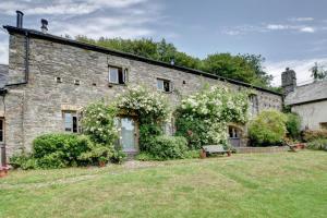 een oud stenen huis met bloemen erop bij Mole Cottage in Parracombe