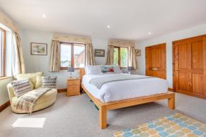 a bedroom with a large bed and a chair at Cascade in Saundersfoot +43 photos