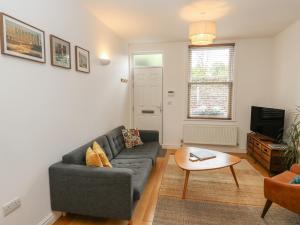 a living room with a couch and a table at Potters Cottage in Sheffield
