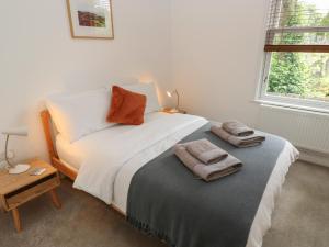 a bedroom with a bed with two towels on it at Potters Cottage in Sheffield