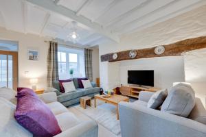 a living room with two couches and a tv at Pwllglas in Darowen