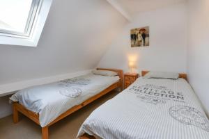 two twin beds in a room with a window at 243 Cae Du in Abersoch