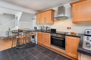 a kitchen with wooden cabinets and a counter top at 243 Cae Du in Abersoch