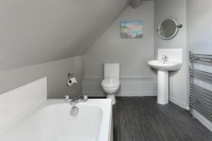 a white bathroom with a toilet and a sink at 243 Cae Du in Abersoch +17 photos
