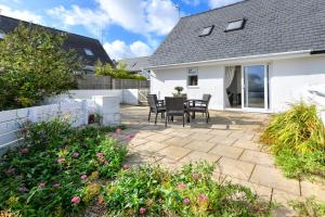 a patio with a table and chairs in a house at 243 Cae Du in Abersoch