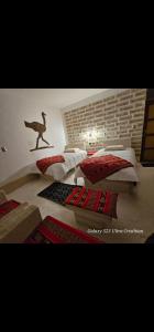 a bedroom with two beds with a dinosaur on the wall at Hotel KAMANA in Chantani