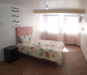 库斯科Samaya shared apartment的一间带床和窗户的小卧室