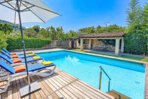 a swimming pool with lounge chairs and an umbrella at Villa Rafaleta by Villa Plus in Pollença