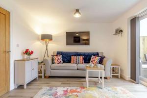 ein Wohnzimmer mit Sofa und Tisch in der Unterkunft Buttercup Cottage in Saint Ervan