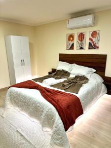 a bedroom with a large bed with a red blanket at Chalés Montana in Domingos Martins