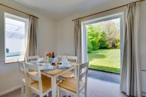 une salle à manger avec une table et des chaises et une fenêtre dans l'établissement Ty Gwyn, à Llanbedrog