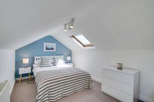 une chambre avec un lit et un mur bleu dans l'établissement Ty Gwyn, à Llanbedrog